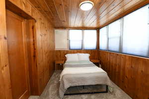 Bedroom with wooden walls and wood ceiling