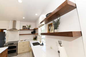 Kitchen with open shelves, stainless steel range with electric stovetop, wall chimney range hood, recessed lighting, and freestanding refrigerator