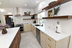 Kitchen with open shelves, wall chimney exhaust hood, stainless steel appliances, pendant lighting, and light stone counters