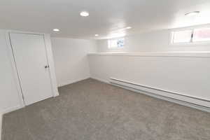 Basement featuring a baseboard heating unit, carpet flooring, and recessed lighting