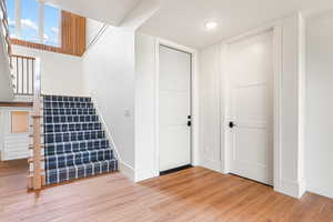 Stairs with wood finished floors and recessed lighting