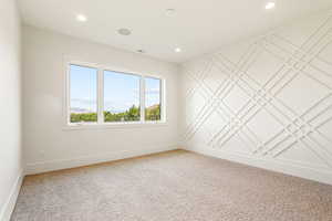Carpeted spare room featuring baseboards and recessed lighting