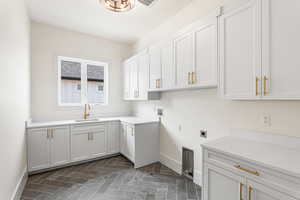 Laundry room featuring electric dryer hookup, washer hookup, and cabinet space