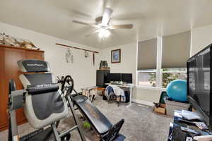 Workout area with ceiling fan and carpet flooring