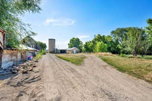 View of dirt / gravel road featuring a barn