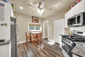 Kitchen with appliances with stainless steel finishes, recessed lighting, ceiling fan, white cabinetry, and wood finished floors