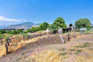 View of yard featuring an outdoor structure, an exterior structure, a view of rural / pastoral area, and a mountain view