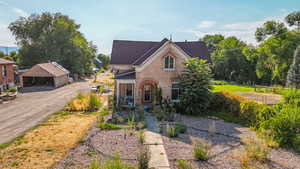 View of front of house with brick siding and an outdoor structure