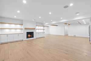 Unfurnished living room with recessed lighting, light wood finished floors, and a fireplace