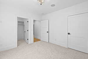 Unfurnished bedroom featuring carpet flooring and a spacious closet