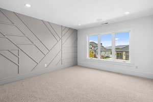 Spare room with carpet flooring, recessed lighting, and a decorative wall