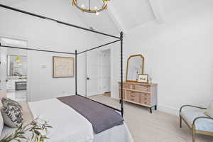 Bedroom featuring a chandelier, high vaulted ceiling, beam ceiling, light carpet, and connected bathroom