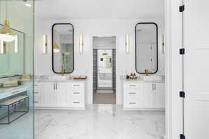 Bathroom featuring marble finish floors and two vanities