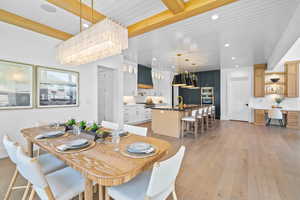 Dining space with light wood-type flooring, recessed lighting, and a wood ceiling with exposed beams