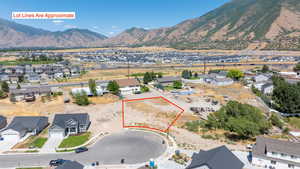 Aerial view of residential area featuring property parcel outlined and a mountain backdrop