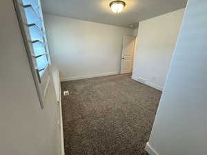 Empty room featuring carpet floors and a textured ceiling