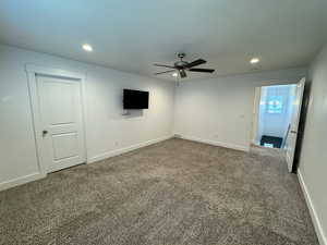 Carpeted spare room with a ceiling fan and recessed lighting