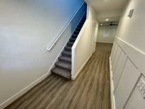 Corridor featuring stairs, wood finished floors, and recessed lighting