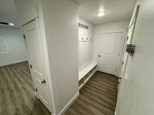 Hall with dark wood-style flooring and baseboards