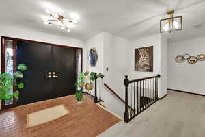 Foyer with a chandelier and brick flooring