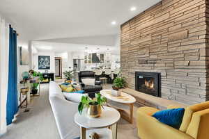 Living room with a fireplace, light wood-style floors, and recessed lighting