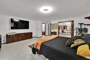 Bedroom with light wood-style floors and a textured ceiling