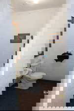 Half bathroom featuring dark tile patterned floors, crown molding, and concrete block wall