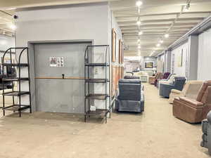 Below grade area featuring track lighting and light carpet