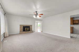 Unfurnished living room featuring light carpet and ceiling fan