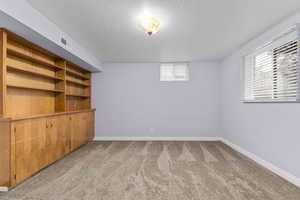 Basement with carpet flooring and a textured ceiling