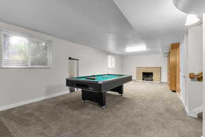 Game room with billiards table, carpet, a textured ceiling, and a fireplace with flush hearth