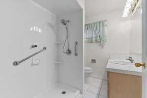 Bathroom with tile patterned flooring, a shower, and vanity