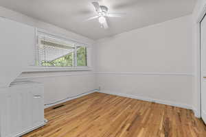 Spare room featuring light wood-type flooring, washer / dryer, and a ceiling fan