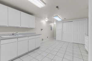 Kitchen featuring light countertops, white cabinets, and light tile patterned flooring