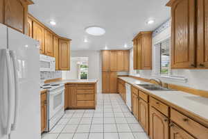 Kitchen featuring white appliances, light countertops, recessed lighting, light tile patterned floors, and ceiling fan