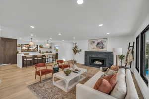 Living area with a premium fireplace, recessed lighting, and light wood-style flooring