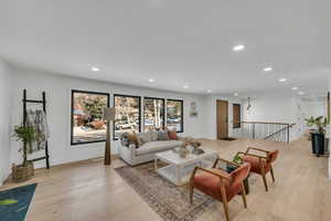 Living room with light wood-style flooring and recessed lighting