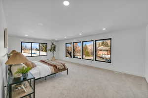 Bedroom with light colored carpet and recessed lighting