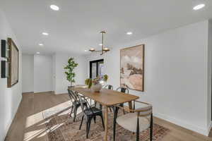 Dining area with light wood finished floors and recessed lighting