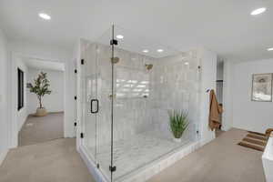 Bathroom with a shower stall, tile patterned flooring, and recessed lighting