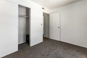 Unfurnished bedroom with carpet and a closet