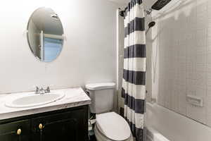 Bathroom featuring shower / tub combo with curtain and vanity