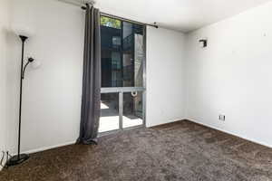 Carpeted empty room featuring baseboards