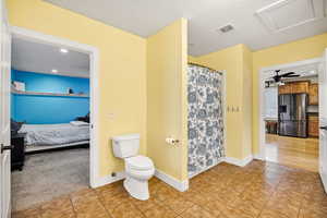 Ensuite bathroom featuring recessed lighting, tile floors, a shower with shower curtain, and a textured ceiling