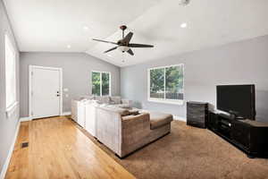 Living room with a ceiling fan, vaulted ceiling, light wood-style flooring, a textured ceiling, and recessed lighting