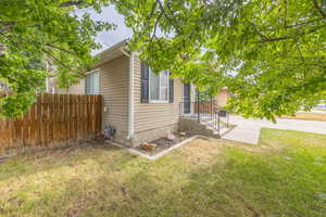 View of home's exterior vinyl siding black shutters an black door with black metal railing