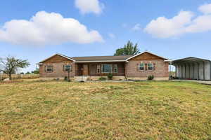 Ranch-style house with a detached carport, covered porch, brick siding, and crawl space
