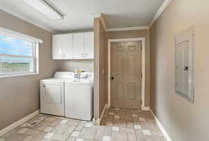 Laundry area featuring cabinet space, ornamental molding, independent washer and dryer, and electric panel