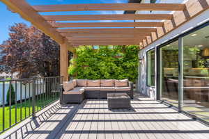 Wooden deck with a pergola and outdoor lounge area