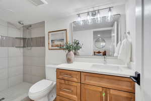 Bathroom with tiled shower and vanity